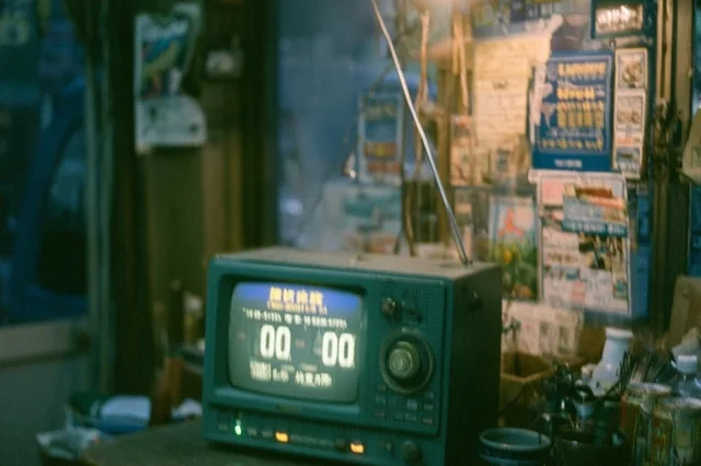 A vintage handmade radio glowing on a cluttered shop counter at night